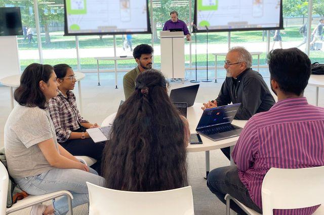 Leap of Faith创始人Frank Nayemi-Rad说, 左二, confers with interns at the Health Tech Talent Institute at 威尼斯人平台.